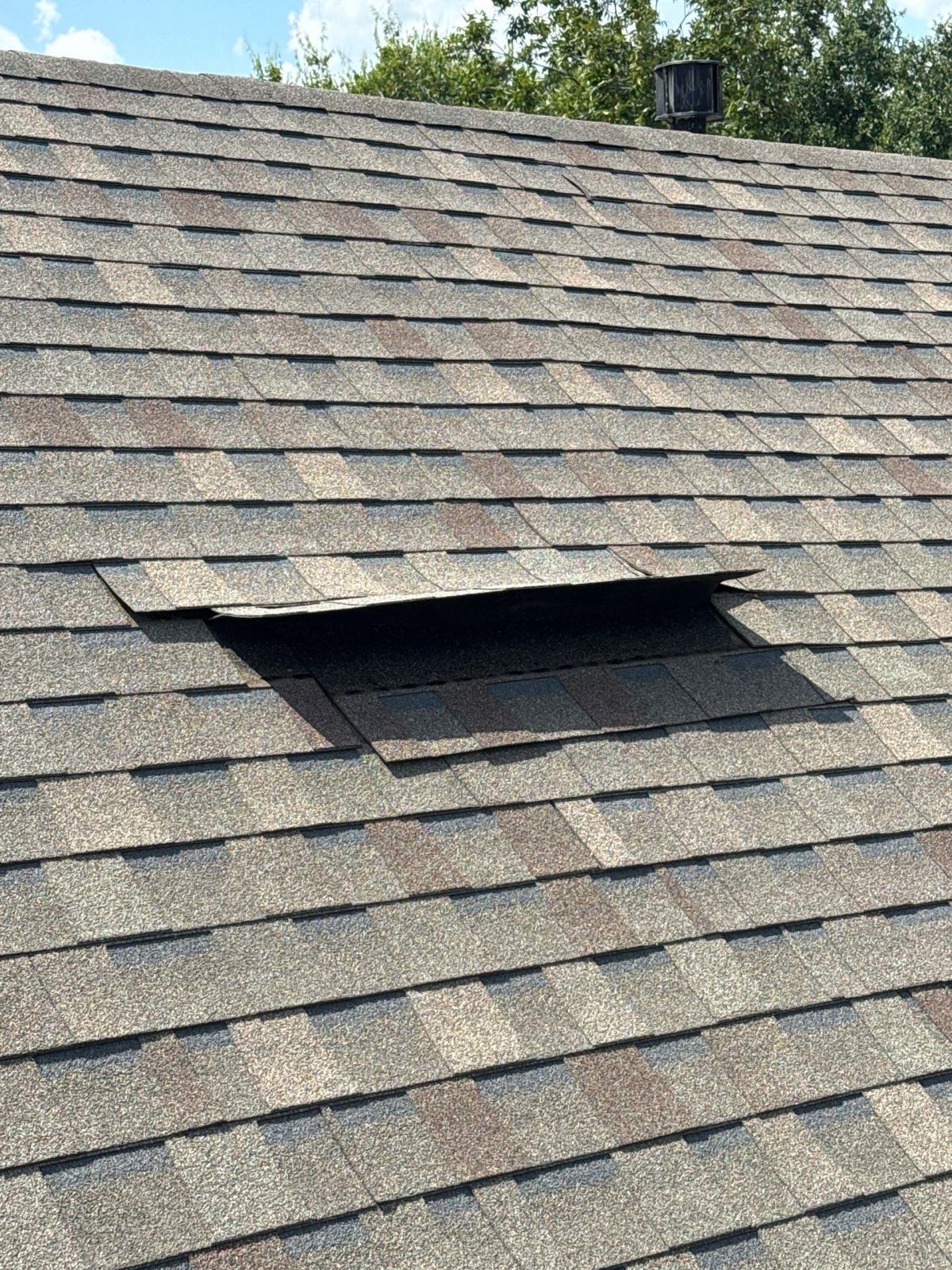 Shingle course lifted and folded back by wind