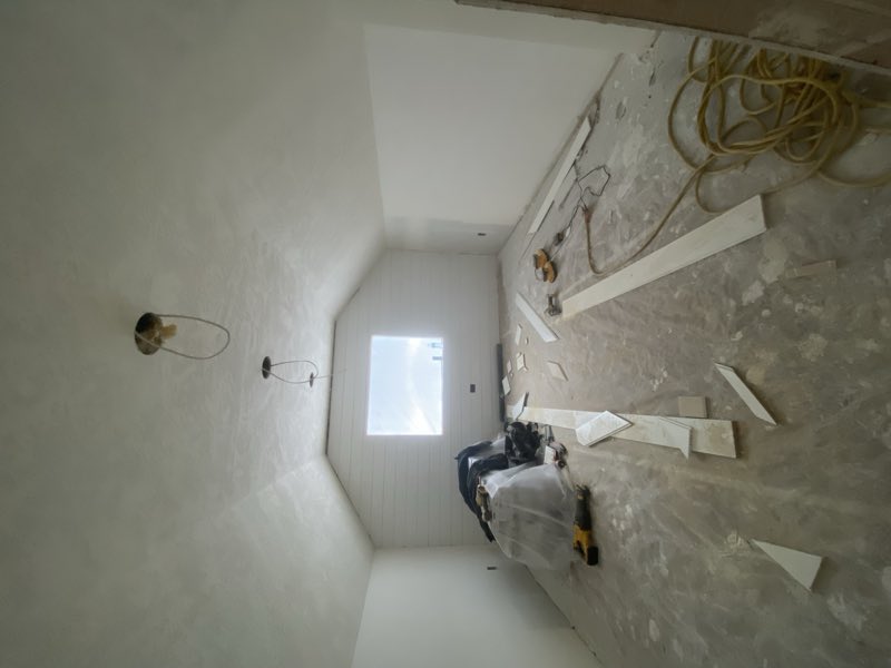 Attic room drywalled with trim staged on the floor